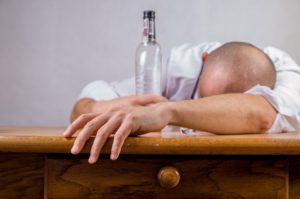 bald man drunk head down
